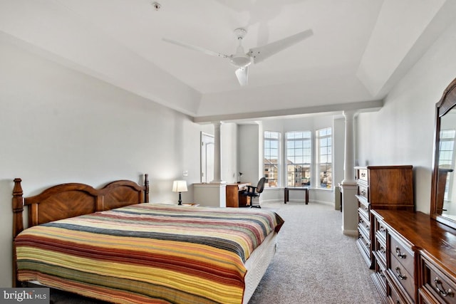 bedroom featuring decorative columns, ceiling fan, and light colored carpet