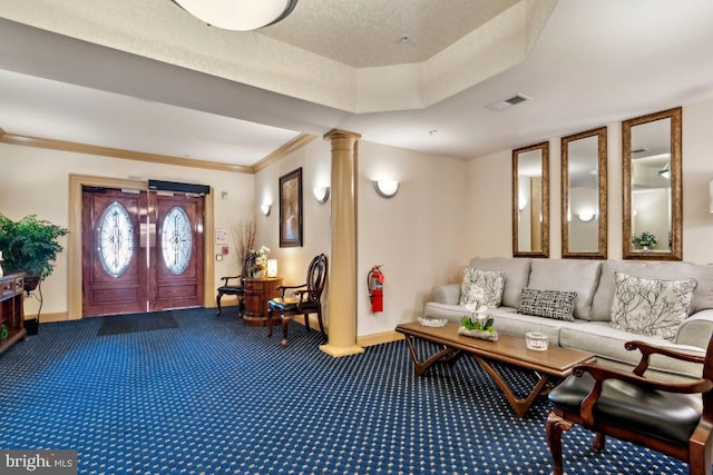 interior space featuring a tray ceiling, ornamental molding, and ornate columns