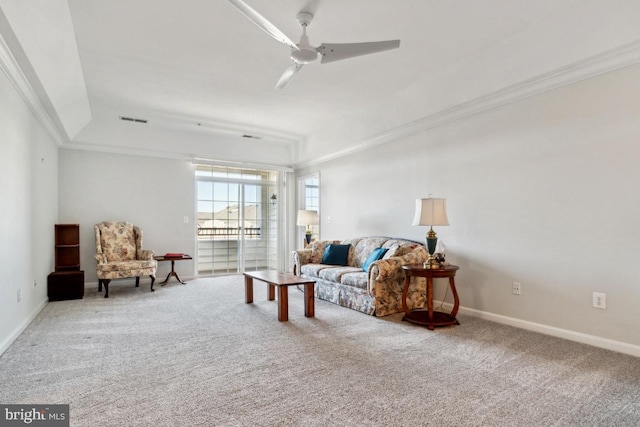 carpeted living room featuring ceiling fan, ornamental molding, and a tray ceiling