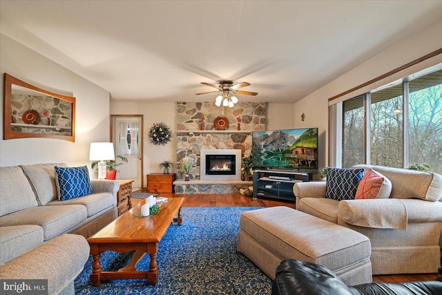 living room with ceiling fan, a fireplace, and hardwood / wood-style flooring