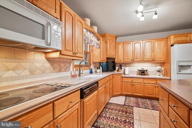 kitchen featuring sink, backsplash, white appliances, and light tile patterned floors