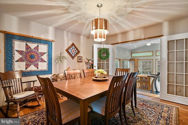 dining room featuring lofted ceiling, french doors, wood-type flooring, and ceiling fan