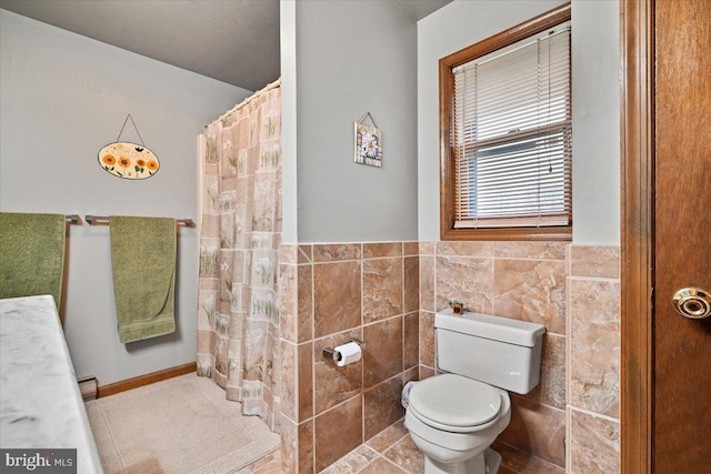 bathroom with tile walls, toilet, tile patterned floors, and walk in shower