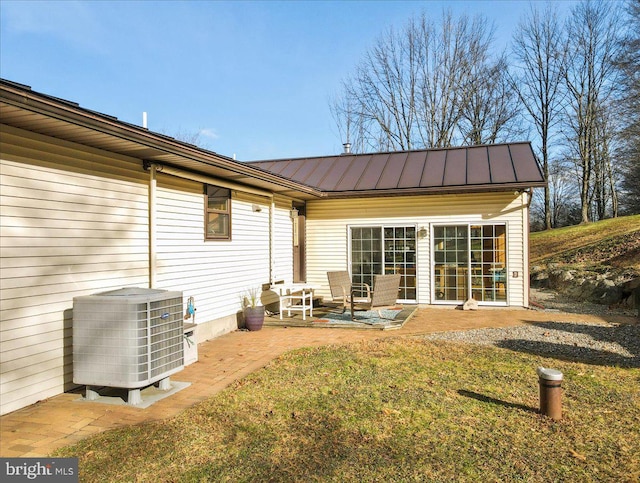 rear view of house with a yard, central AC unit, and a patio