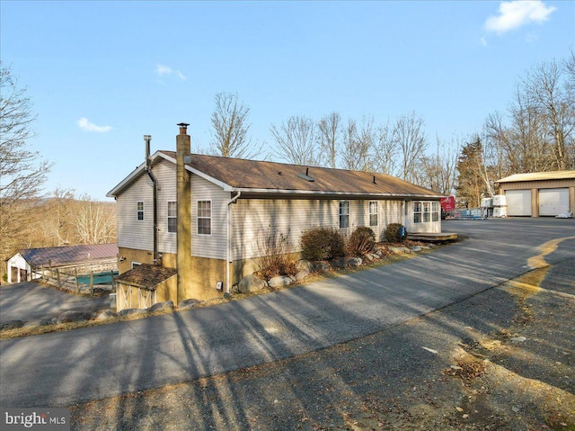 view of property exterior featuring a garage and an outbuilding