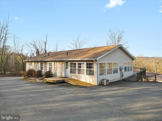 view of front of property with central AC unit and a wooden deck