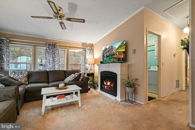 carpeted living room with washer / clothes dryer, a textured ceiling, lofted ceiling, ceiling fan, and ornamental molding