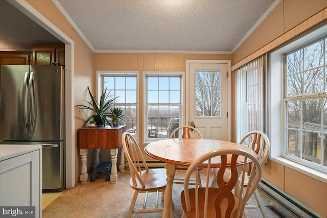 dining room with a textured ceiling, a healthy amount of sunlight, and light colored carpet