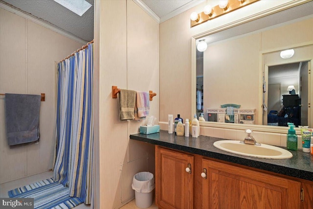 bathroom featuring ornamental molding, a skylight, vanity, and a textured ceiling