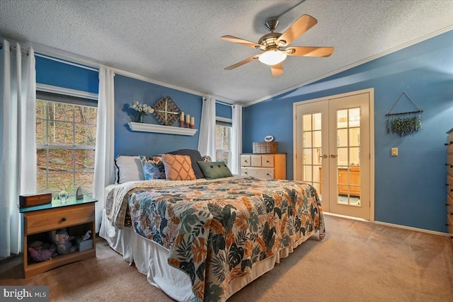 carpeted bedroom with french doors, multiple windows, a textured ceiling, and ceiling fan