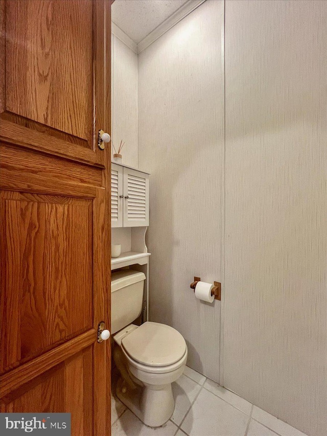 bathroom featuring toilet, tile patterned flooring, and crown molding