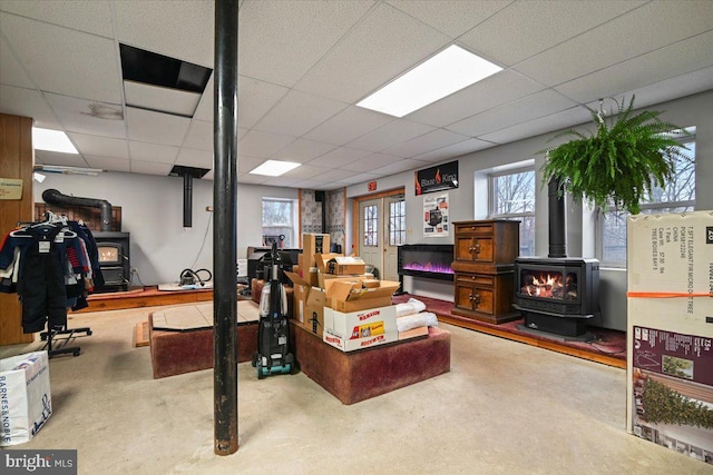 interior space featuring a wood stove and a drop ceiling