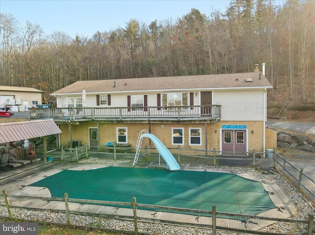 rear view of house featuring a patio area, a balcony, and a swimming pool side deck