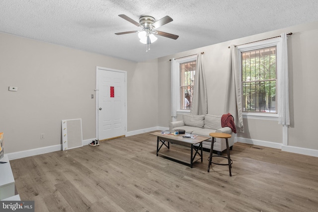 sitting room featuring a textured ceiling, light wood-type flooring, and ceiling fan