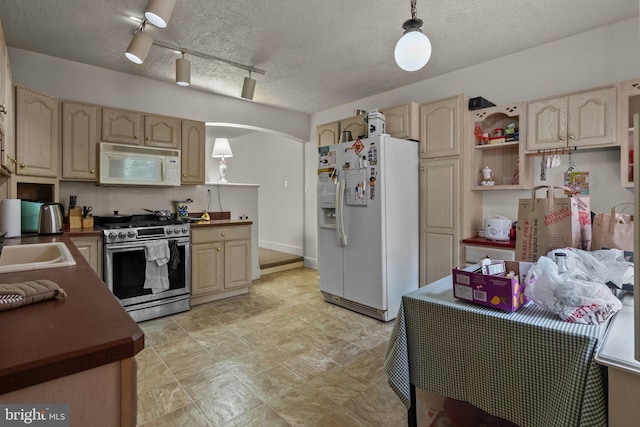 kitchen with white appliances, track lighting, decorative light fixtures, and a textured ceiling