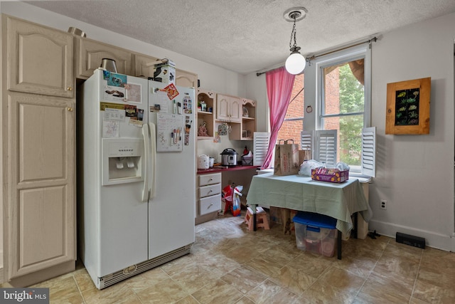 kitchen featuring a textured ceiling, pendant lighting, and white refrigerator with ice dispenser