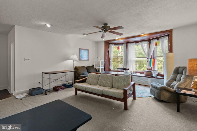 living room with a textured ceiling, ceiling fan, and carpet flooring