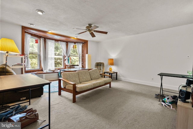 living room featuring a textured ceiling, light carpet, and ceiling fan