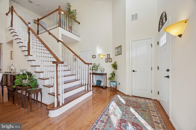 entrance foyer featuring a towering ceiling and hardwood / wood-style floors