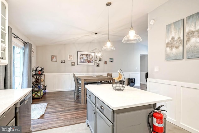 kitchen featuring lofted ceiling, gray cabinets, dishwasher, and hanging light fixtures