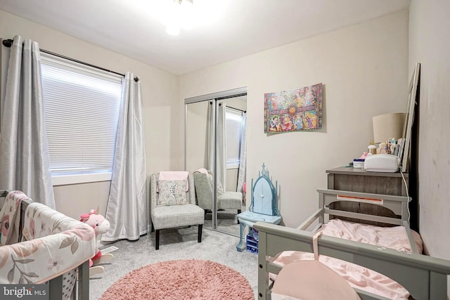 bedroom featuring multiple windows, a closet, and light carpet