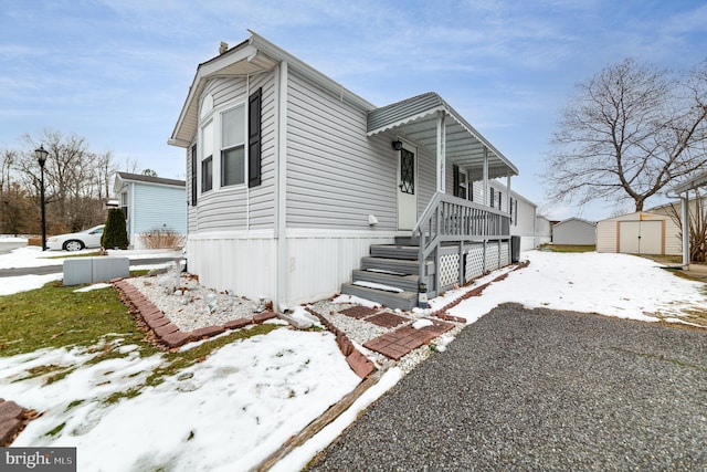 view of front of property featuring a storage shed