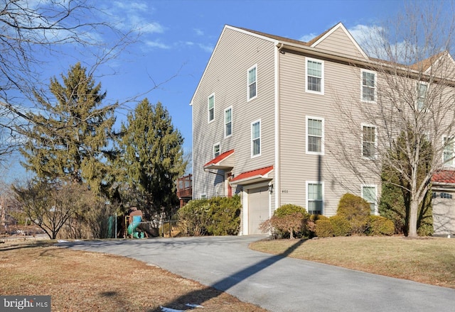 view of property exterior featuring a lawn and a garage