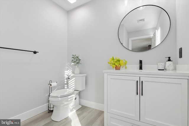 bathroom with wood-type flooring, vanity, and toilet