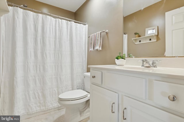 bathroom with toilet, vanity, and tile patterned floors