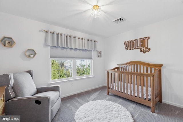 bedroom with a crib and carpet floors