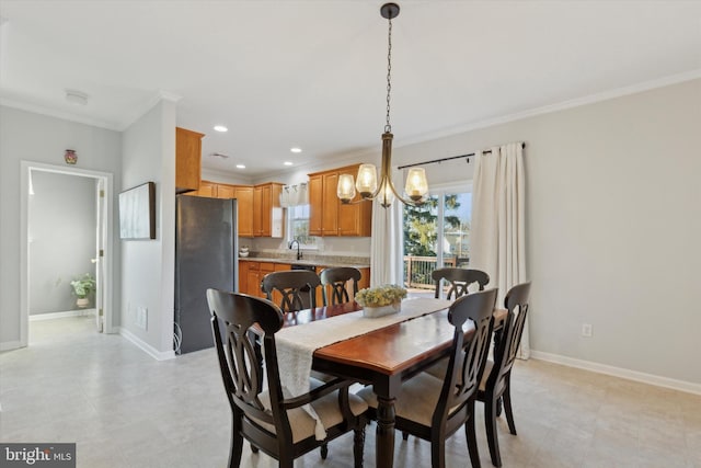 dining space featuring sink, a notable chandelier, and crown molding