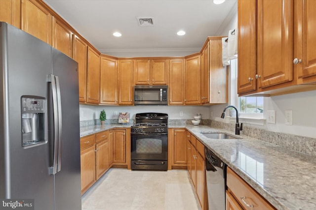 kitchen featuring stainless steel appliances, light stone countertops, ornamental molding, and sink