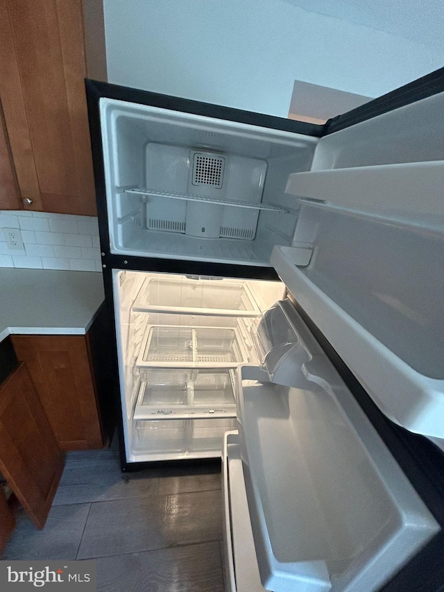 room details featuring refrigerator and decorative backsplash