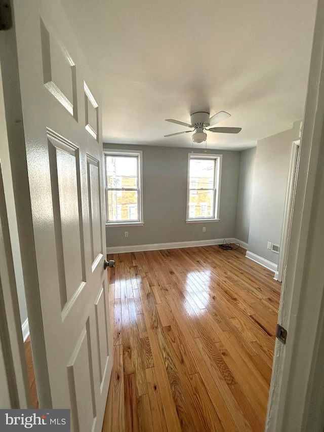 spare room featuring a wealth of natural light, light hardwood / wood-style flooring, and ceiling fan