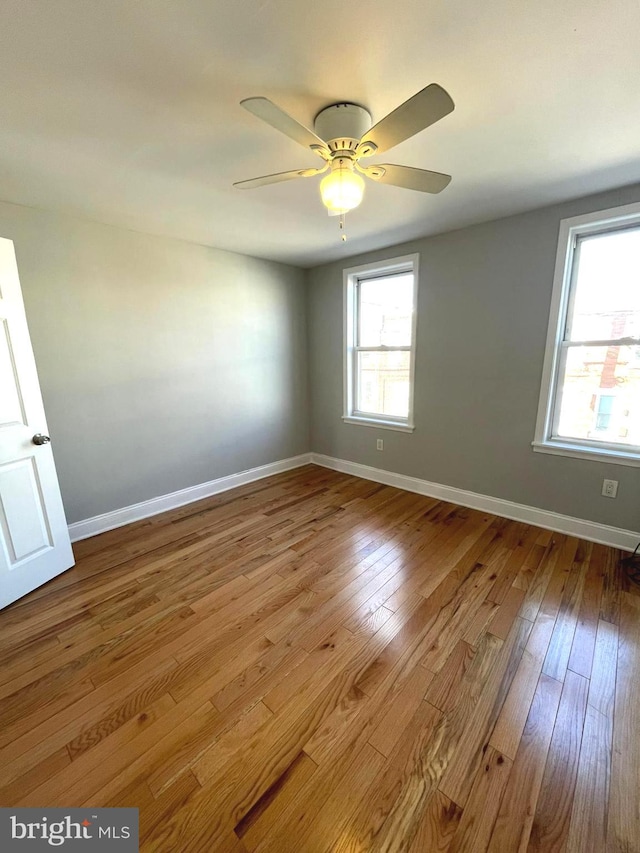 empty room featuring ceiling fan and hardwood / wood-style floors