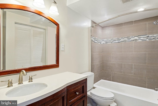 full bathroom featuring toilet, tiled shower / bath, and vanity