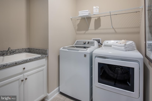 washroom with sink, washer and clothes dryer, and light tile patterned floors