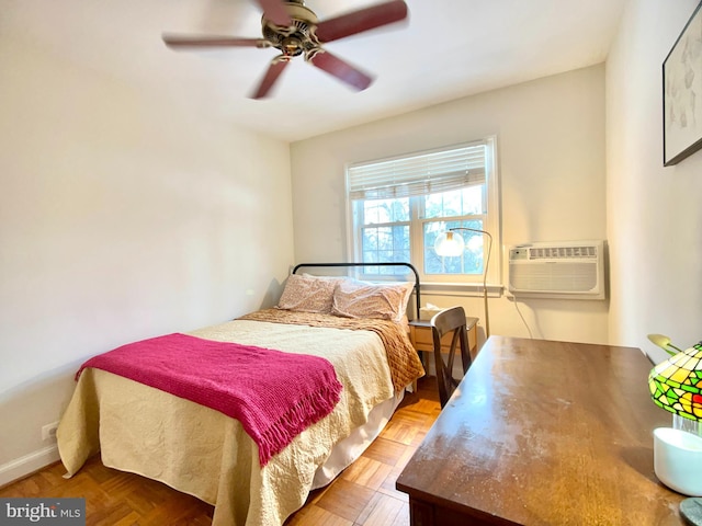 bedroom with a wall unit AC, ceiling fan, and parquet floors