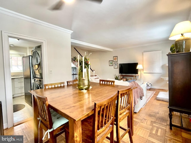 dining area with ornamental molding, light parquet floors, and stacked washer and dryer