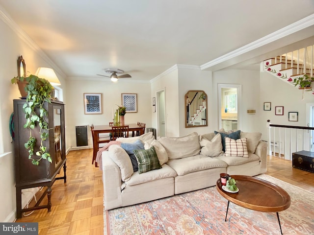 living room with ceiling fan, crown molding, and light parquet floors