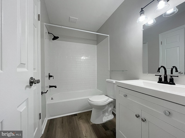 full bathroom with toilet, tiled shower / bath combo, hardwood / wood-style floors, and vanity