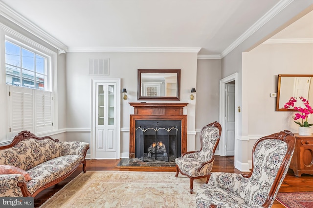 living area with hardwood / wood-style flooring and ornamental molding