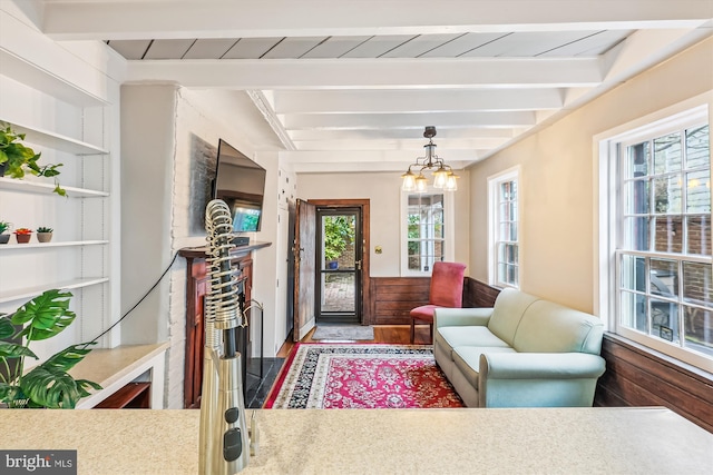 interior space with beam ceiling, hardwood / wood-style floors, built in features, and a notable chandelier