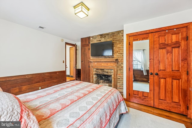 bedroom featuring a fireplace and light hardwood / wood-style floors