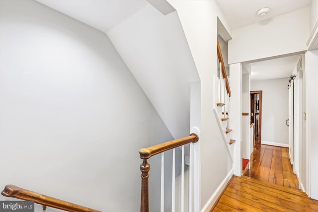 stairway with hardwood / wood-style flooring and a barn door