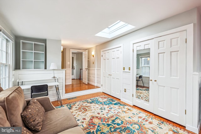 living room with a skylight and light hardwood / wood-style floors