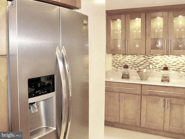 kitchen featuring stainless steel fridge with ice dispenser and backsplash