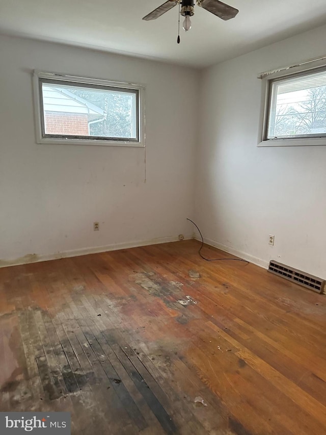 unfurnished room with dark hardwood / wood-style flooring, ceiling fan, and plenty of natural light