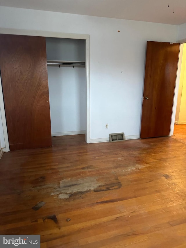 unfurnished bedroom featuring a closet and wood-type flooring