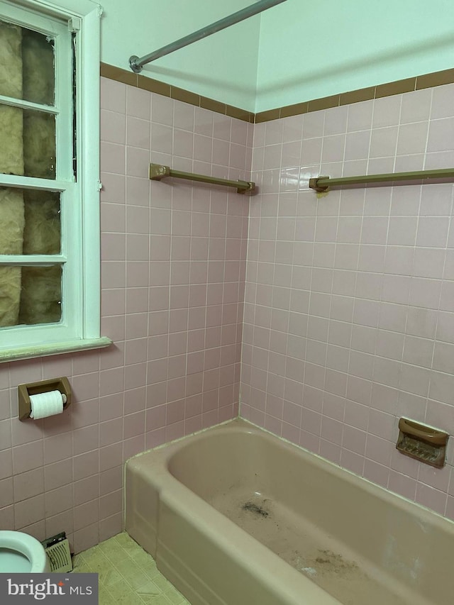 bathroom with tile walls, tile patterned flooring, and tub / shower combination